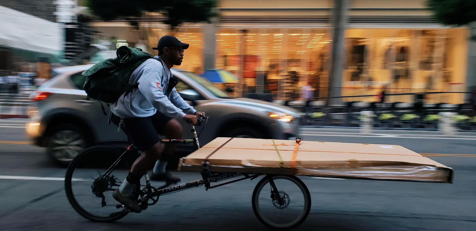 A courier riding a cargo bike through a city street