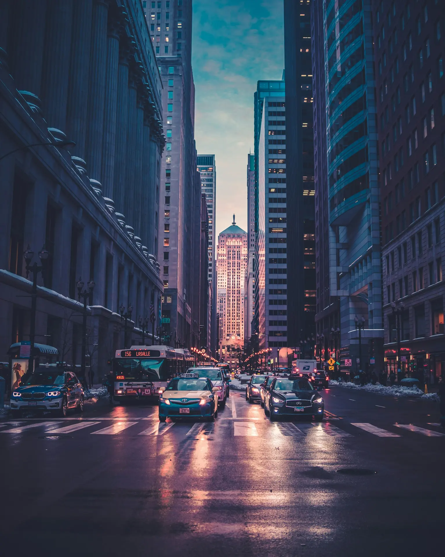 A city street at dusk lined with lit buildings